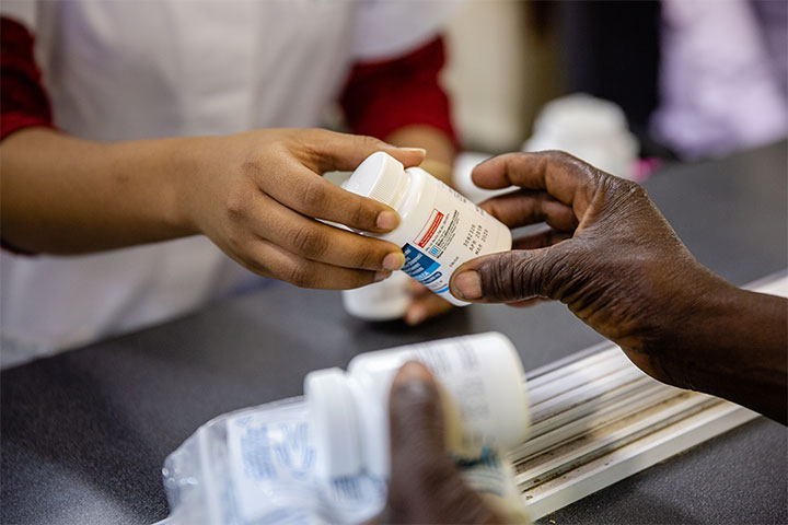 Pharmacist handing over medication to a HIV patient.